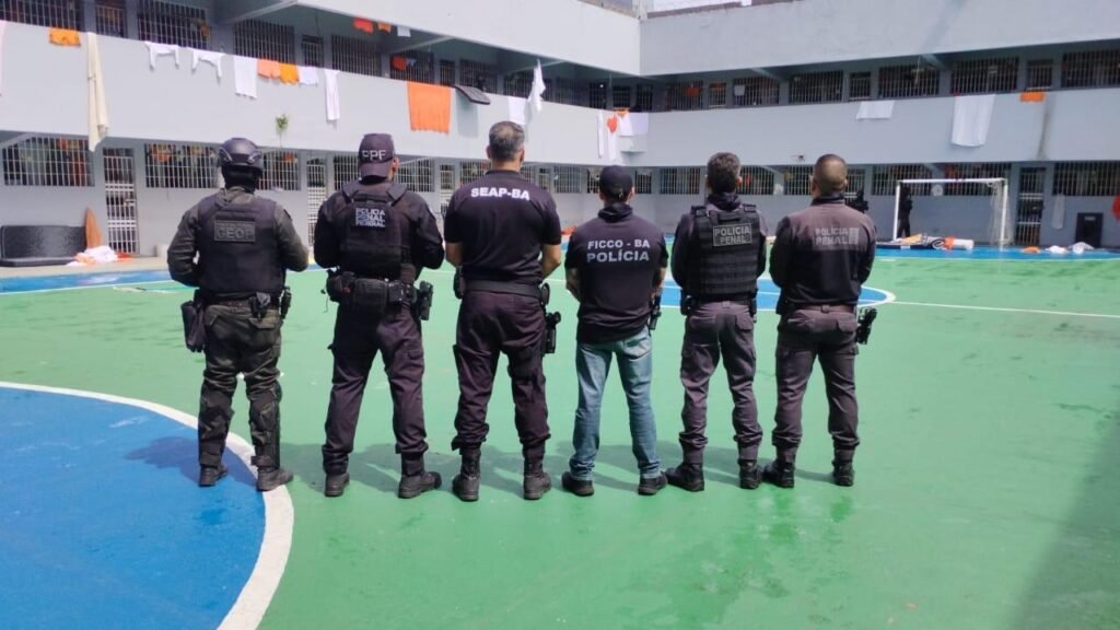 policiais na quadra, centro de um presídio da Bahia