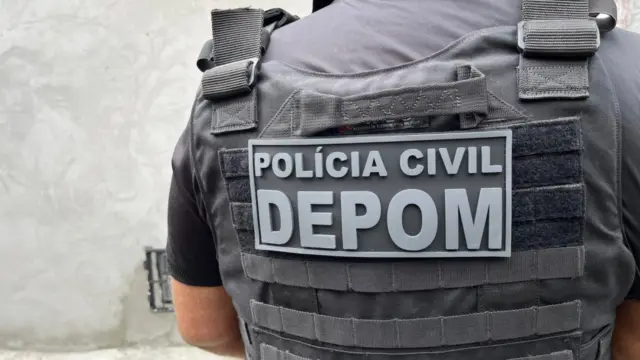 policial civil com colete escrito "depom"