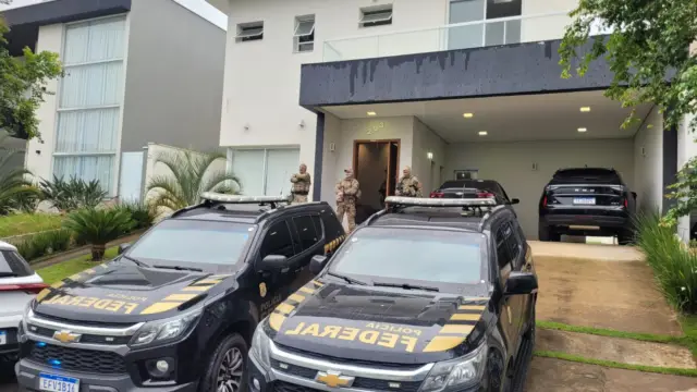 Carros da PF estacionados em frente a residência de investigados