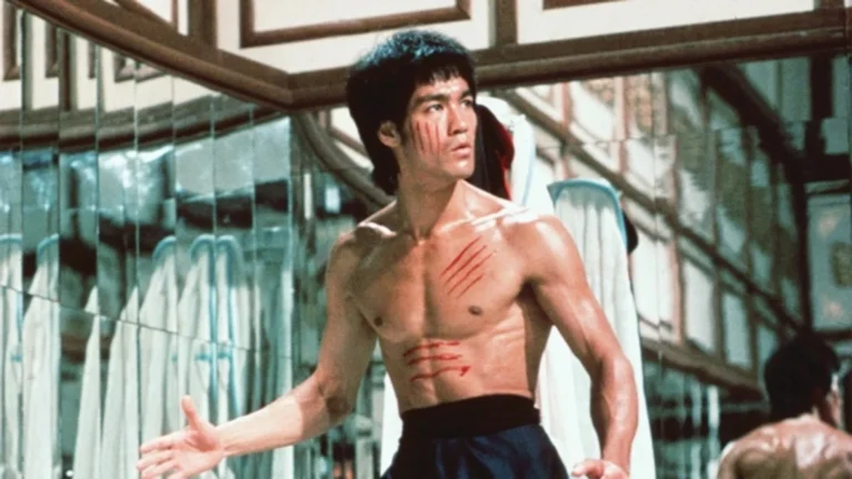 Bruce Lee em cena de filme de artes marciais, com expressão séria