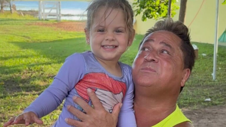 Maria Flor sorri ao lado do avô Leonardo, que a abraça