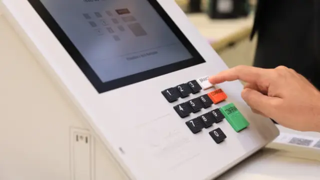 pessoa votando na urna eletrônica brasileira (simulação)